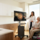 Eye doctor reviewing AI-assisted retinal imaging with a patient during an eye exam in a modern optometry practice.